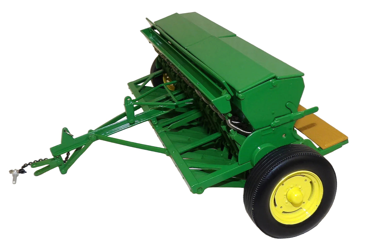 Model of a green agricultural implement with yellow wheels on a white background